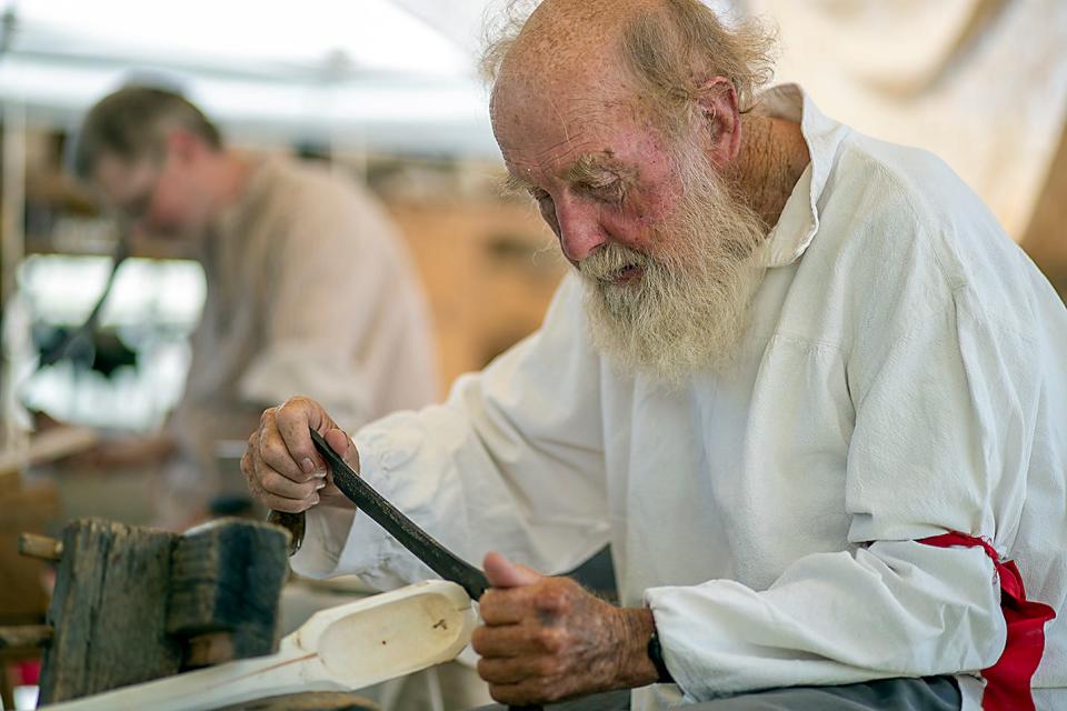 Robert Grady, right, of Trivoli crafts a piece of wood inside the Tall Robert's Handmade Wooden Paddles tent at the rendezvous camp side of the 26th Annual Galesburg Heritage Days on Sunday, Aug. 22, 2021 at Lake Storey.