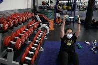 Mayra Miranda, 34, wears a mask while exercising at a gym in Los Angeles. Friday, June 26, 2020. With the coronavirus surging, at least four California counties on Friday paused or prepared to backtrack on their reopening plans in a bid to halt the spread of the virus. (AP Photo/Jae C. Hong)