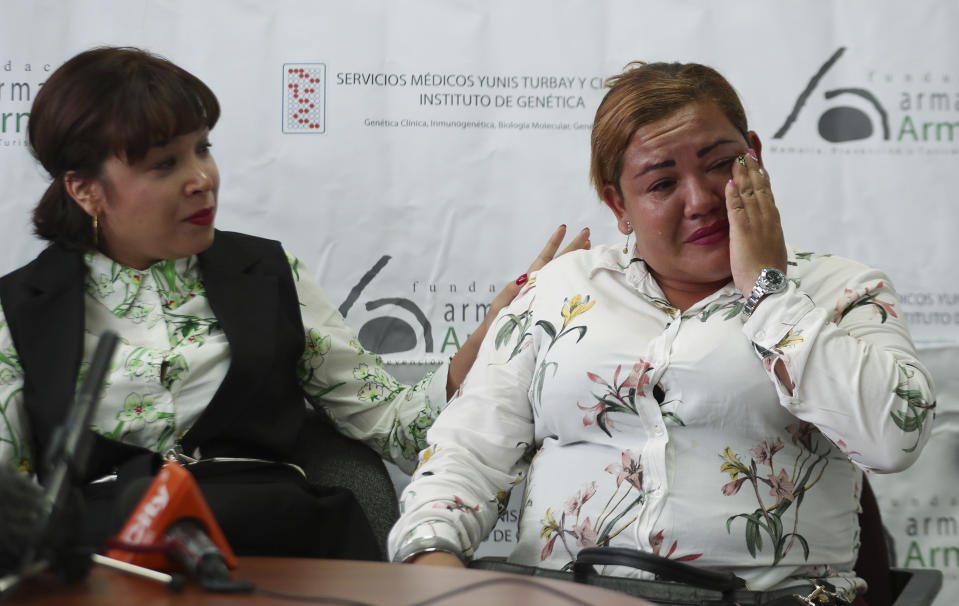 Jenifer De La Rosa, left, comforts her sister Angela Rendon, right, during a press conference in Bogota, Colombia, Thursday, Nov. 14, 2019. The story of the lost sisters could be one of many involving children who were separated from their parents after the Nevado del Ruiz erupted, rescued from the rubble and later put up for adoption after no relative arrived to claim them . A genetic institute in Colombia's capital confirmed through DNA testing that Jenifer De La Rosa and Angela Rendon are sisters. (AP Photo/Fernando Vergara)