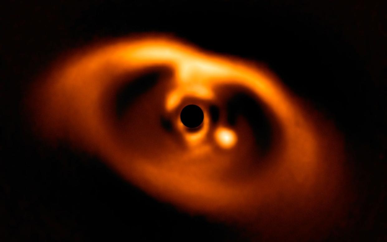 Scientists have for the first time witnessed the birth of a planet, a huge gas giant many times the size of Jupiter, swirling into existence 370 light years from Earth  - ESO/A. Müller et al