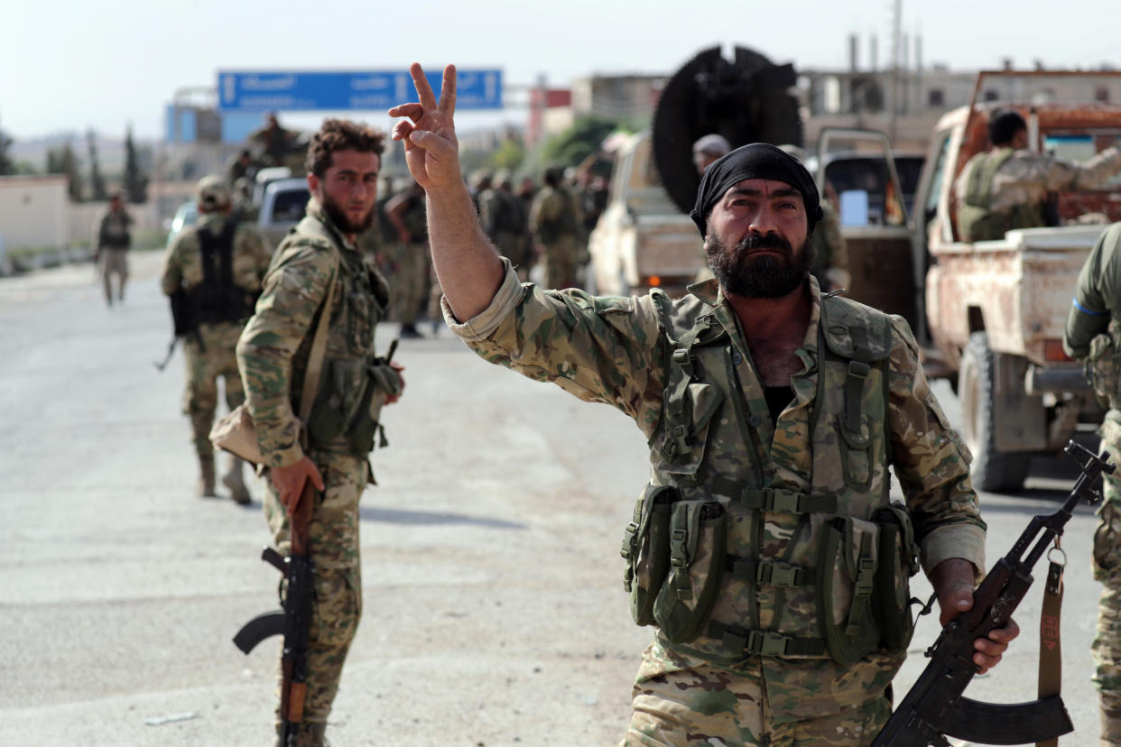 A Turkey-backed Syrian rebel fighter gestures to the camera at the border town of Tel Abyad, Syria, October 14, 2019. REUTERS/Khalil Ashawi