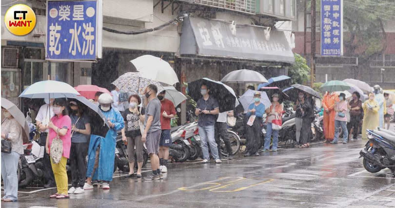 民眾冒雨排隊搶購唾液快篩劑。（圖／趙文彬攝）