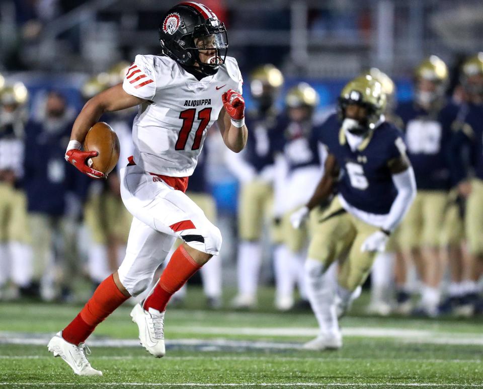Aliquippa's Cameron Lindsey (11) runs the ball into the end zone for a touchdown after intercepting the ball against Bishop McDevitt in the first quarter of the PIAA Class 4A championship football game, Dec. 9, 2021, at HersheyPark Stadium in Hershey. The Quips defeated the Crusaders 34-27. 