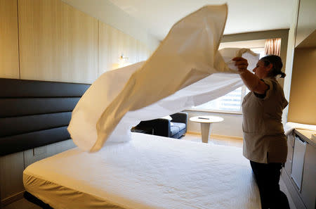 A chambermaid who works at a hotel where chambermaids are members of staff and not associated with the "Kellys" association, makes a bed in Madrid, Spain, July 26, 2018. Picture taken July 26, 2018. REUTERS/Paul Hanna