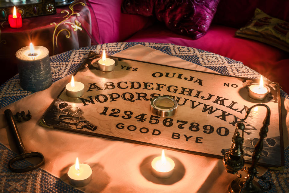 ouija board set up on a table surrounded by candles