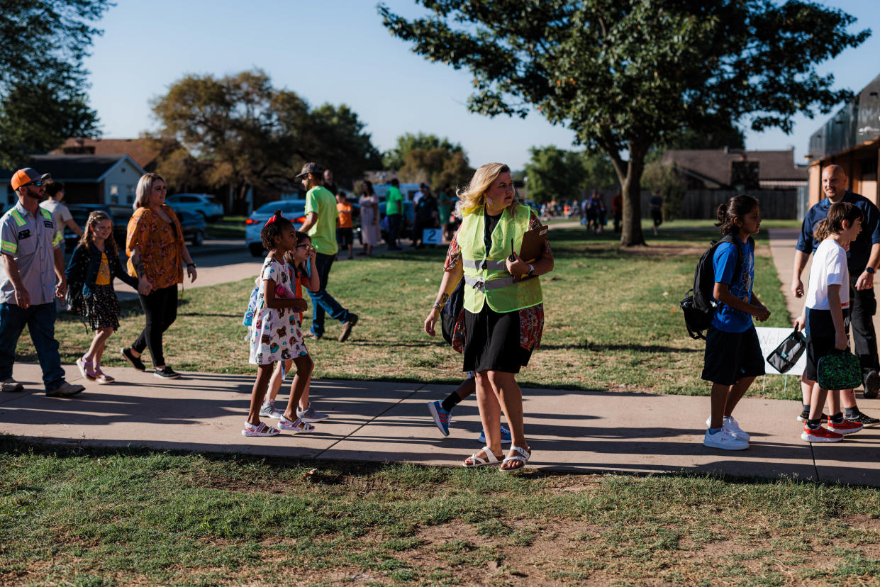 Bartlesville teachers help guide students to class on the first day of school at Wilson Elementary on Aug. 11.