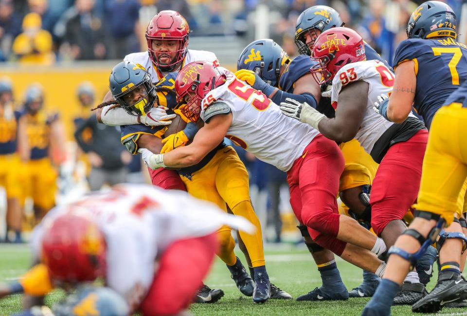 Zach Petersen (55) tackles West Virginia's Tony Mathis Jr. (24) during a game on Oct. 30. Petersen has been a staple of the Cyclones' defense, described by coach Matt Campbell as a "pillar of consistency."