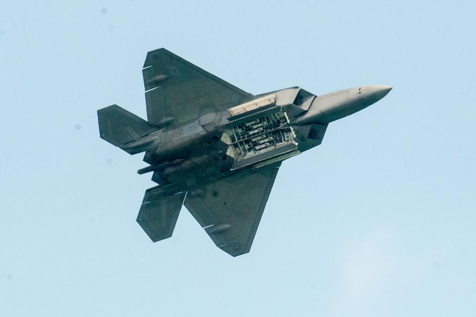A USAF F-22 Raptor shows its bomb hatches for the crowd.
