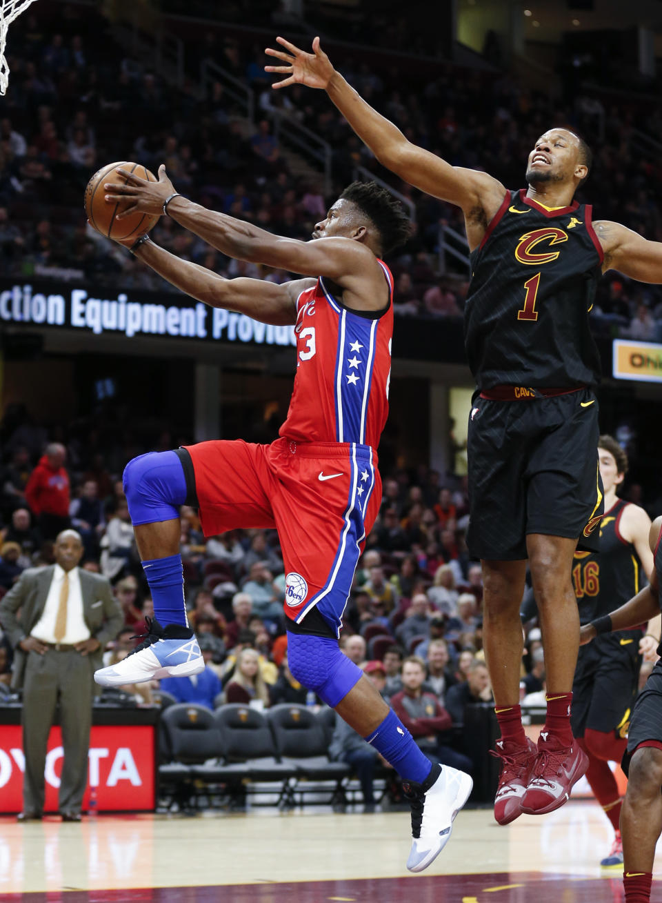 Philadelphia 76ers' Jimmy Butler (23) scores past Cleveland Cavaliers' Rodney Hood (1) during the second half of an NBA basketball game Sunday, Dec. 16, 2018, in Cleveland. (AP Photo/Ron Schwane)