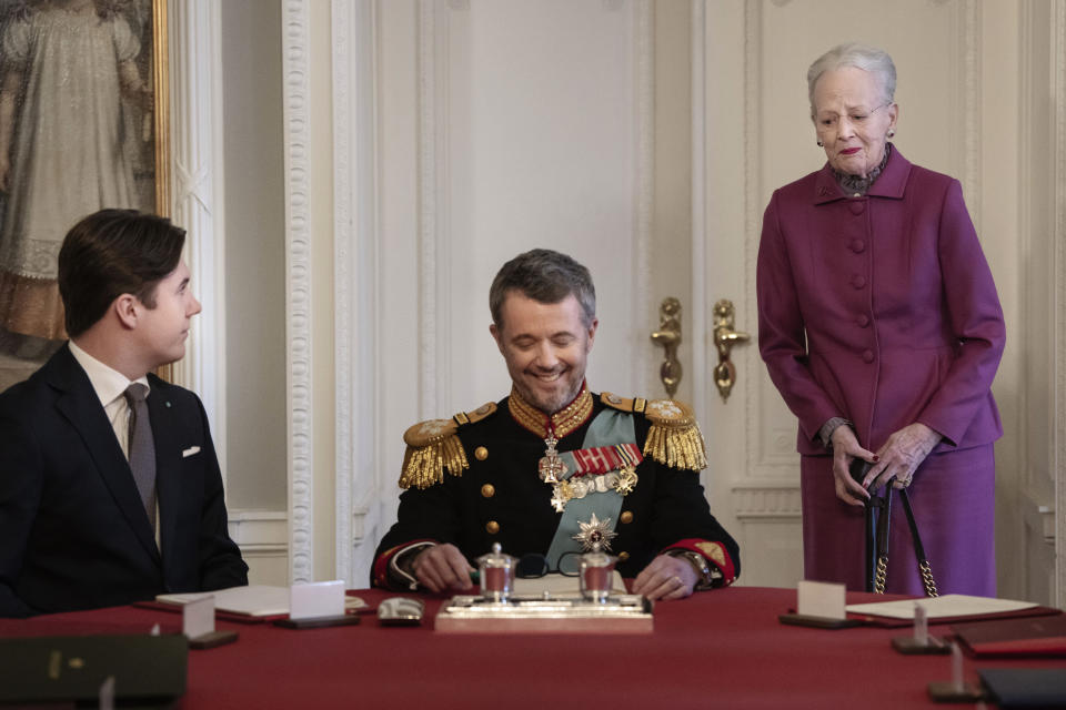 Denmark's King Frederik X takes a seat at the head of the table with Crown Prince Christian at left, after Queen Margrethe II signed a declaration of abdication in a meeting of the Council of State, at Christiansborg Castle, in Copenhagen, Sunday, Jan. 14, 2024. Denmark’s prime minister proclaimed Frederik X as king on Sunday after his mother Queen Margrethe II formally signed her abdication, with massive crowds turning out to rejoice in the throne passing from a beloved monarch to her popular son. (Mads Claus Rasmussen/Ritzau Scanpix via AP)