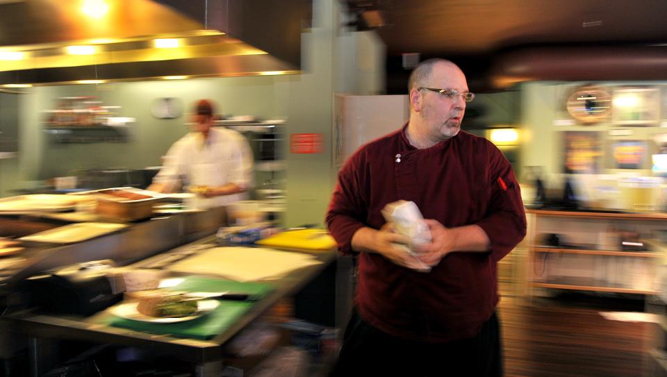 Greg DeSanto, chef and owner of Olio, takes a lunch order to the counter on Monday, July 15, 2013, at his downtown Jacksonville restaurant.