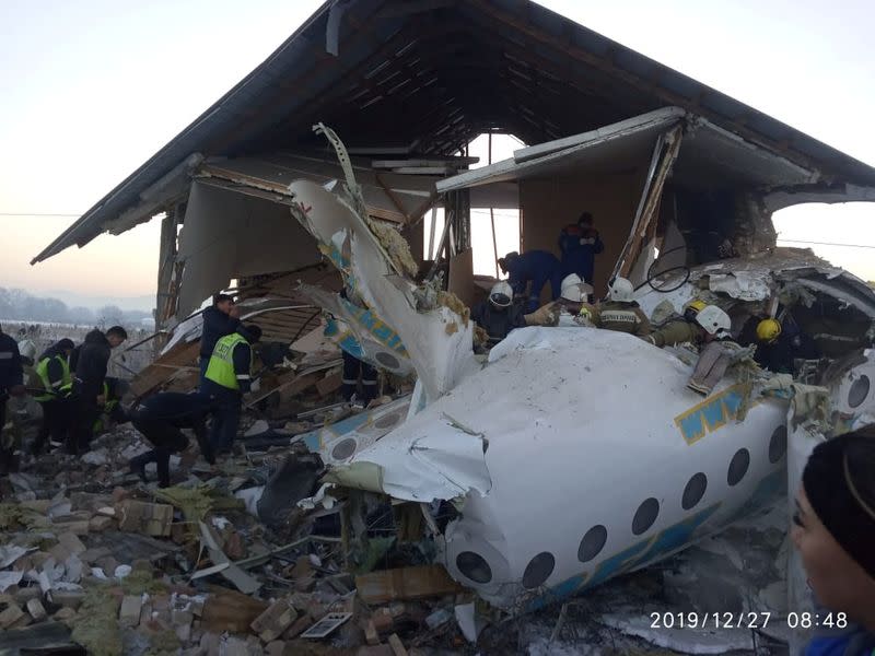 Emergency and security personnel are seen at the site of the plane crash near Almaty