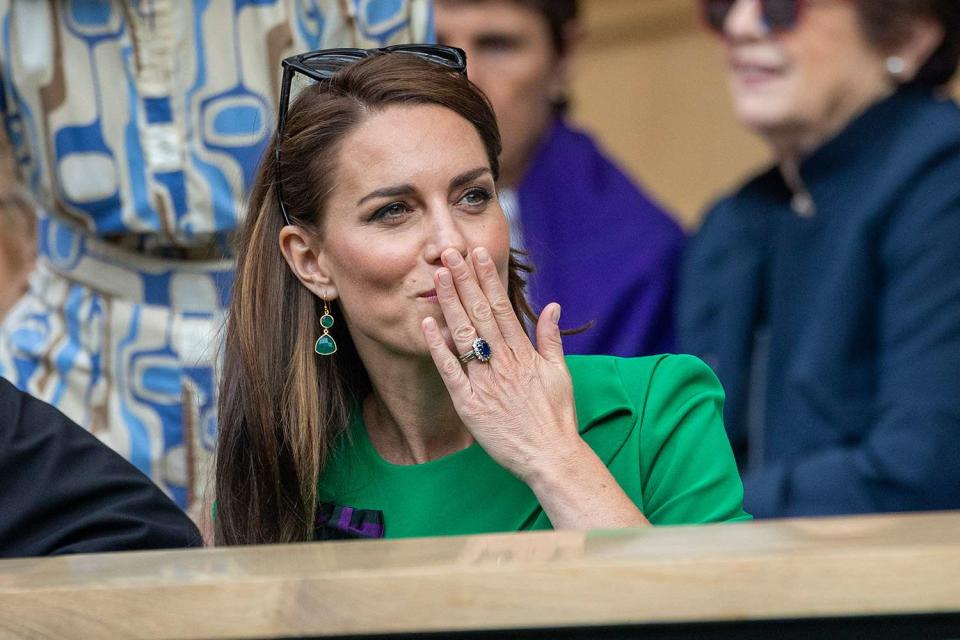 <p>Tim Clayton/Corbis via Getty</p> Kate Middleton blows a kiss from the Royal Box at Wimbledon on July 16.
