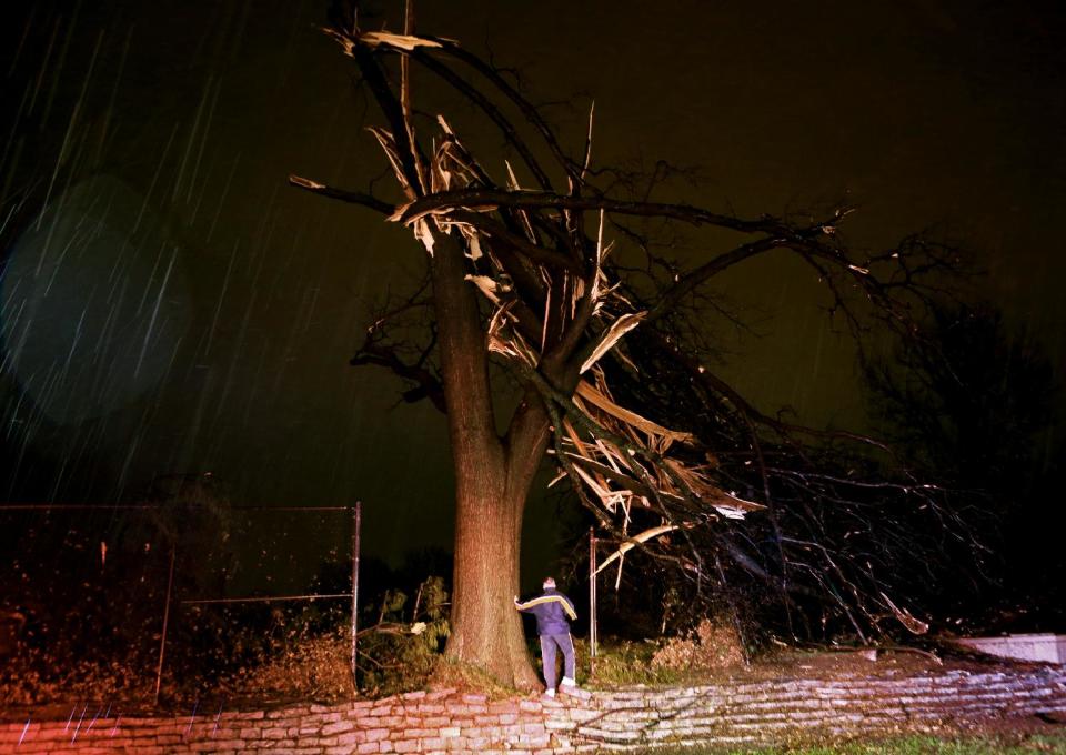 A man surveys damage after a tornado hit and knocked trees down damaging homes and cutting power early Thursday, April 3, 2014 in University City, Mo. Jim Sieveking, of the National Weather Service in St. Louis, says the tornado touched down in the St. Louis suburb, as a strong storm system with intense lightning and heavy rain moved through the St. Louis region. (AP Photo/St. Louis Post-Dispatch, Christian Gooden) EDWARDSVILLE INTELLIGENCER OUT; THE ALTON TELEGRAPH OUT