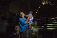 Claudia Maquin, 27, answers questions from journalists with her three children, Elvis Radamel Aquiles Caal Maquin, 5, left, Angela Surely Mariela Caal Maquin, 6 months, middle, and Abdel Johnatan Domingo Caal Maquin, 9, right, in Raxruha, Guatemala, on Saturday, Dec. 15, 2018. Claudia Maquin's daughter, 7-year old Jakelin Amei Rosmery Caal, died in a Texas hospital, two days after being taken into custody by border patrol agents in a remote stretch of New Mexico desert. (AP Photo/Oliver de Ros)