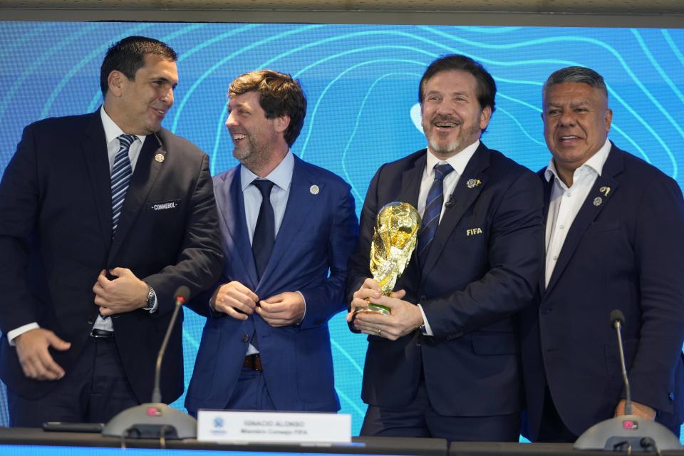 El presidente de la federación de Paraguay Robert Harrison (izquierda), el presidente de la federación de Uruguay Ignacio Alonso (centro), el presidente de la CONMEBOL Alejandro Domínguez (tercero a la izquierda y el presidente de la federación de Argentina Claudio Tapia sostiene el trofeo de la Copa Mundial durante una rueda de prensa, el miércoles 4 de octubre de 2023, en Luque, Paraguay. Domínguez anunció que los partidos inaugurales del Mundial 2030 se jugarán en Argentina, Uruguay y Paraguay. (AP Foto/Jorge Sáenz)