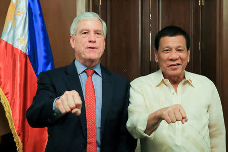 President Rodrigo Duterte poses with his signature fist bump with Australian Secret Intelligence Service Director General Nicolas Peter 'Nick' Warner who paid a courtesy call on the President at the Malacañan Palace, in Manila Philippines, August 22, 2017. Presidential Palace/Handout via REUTERS