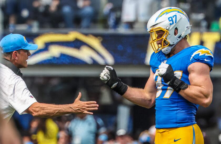 Chargers coach Jim Harbaugh congratulates linebacker Joey Bosa (97) after a drive-ending sack against the Las Vegas Raiders.