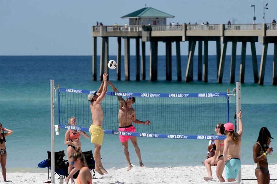 Two players jump for the ball Wednesday during the first day of play in Emerald Coast Volleyball Week. The tournament continues through Sunday at The Boardwalk on Okaloosa Island.