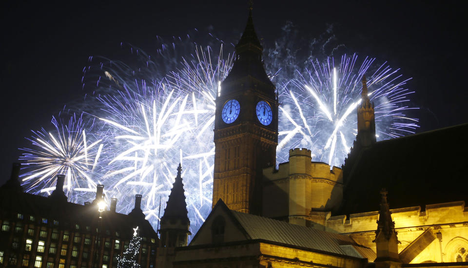 FILE - In this Friday, Jan. 1, 2016, file photo, fireworks explode over the River Thames and the Palace of Westminster's Elizabeth Tower, known as Big Ben, as the New Year's Day celebrations begin in London. If ever a year's end seemed like cause for celebration, 2020 might be it. Yet the coronavirus scourge that dominated the year is also looming over New Year's festivities and forcing officials worldwide to tone them down. (AP Photo/Alastair Grant, File)