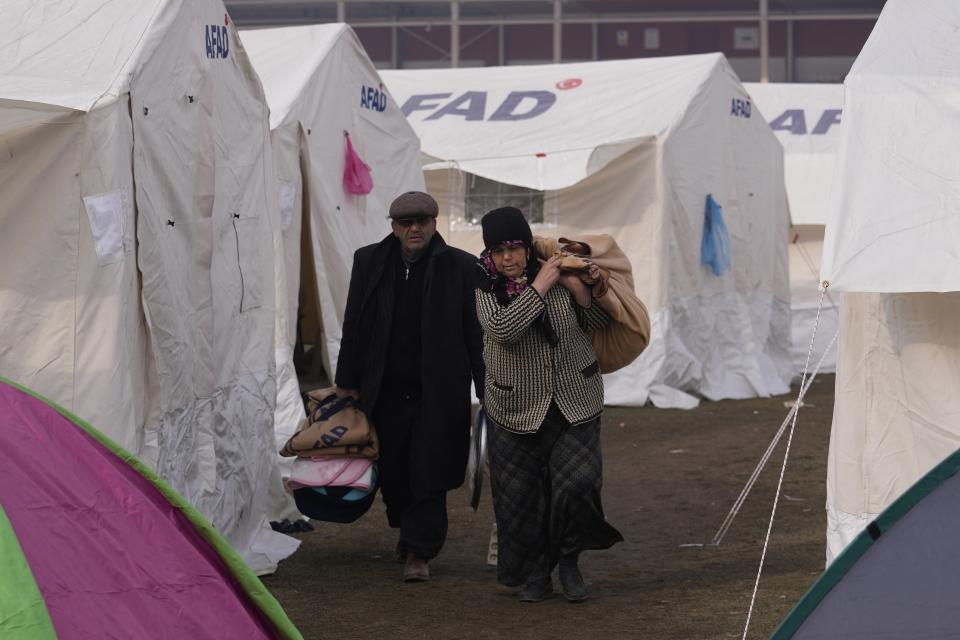 People with their belongings arrive at the tents, in Kharamanmaras, southeastern Turkey, Friday, Feb. 10, 2023. Rescuers pulled several people alive from the shattered remnants of buildings on Friday, some who survived more than 100 hours trapped under crushed concrete in the bitter cold after a catastrophic earthquake slammed Turkey and Syria. (AP Photo/Kamran Jebreili)