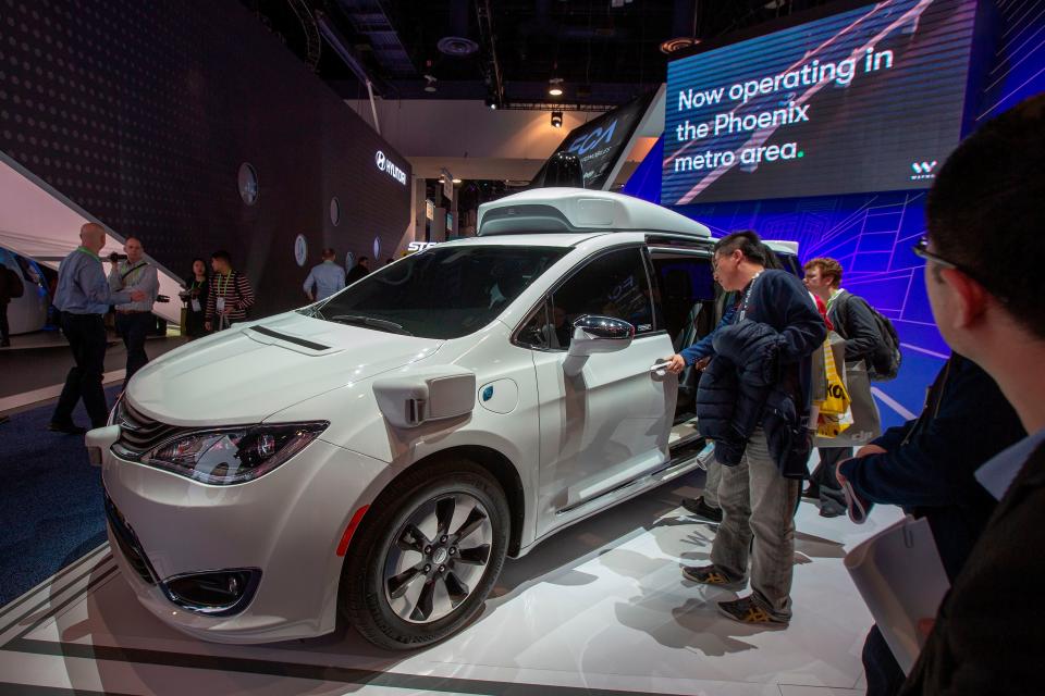 People look at the Waymo car, formerly the Google self-driving car project.