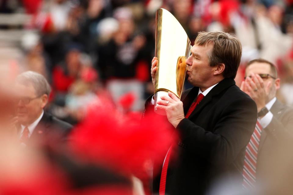 Kirby Smart embraces the national championship trophy during Saturday's celebration at Sanford Stadium in Athens.