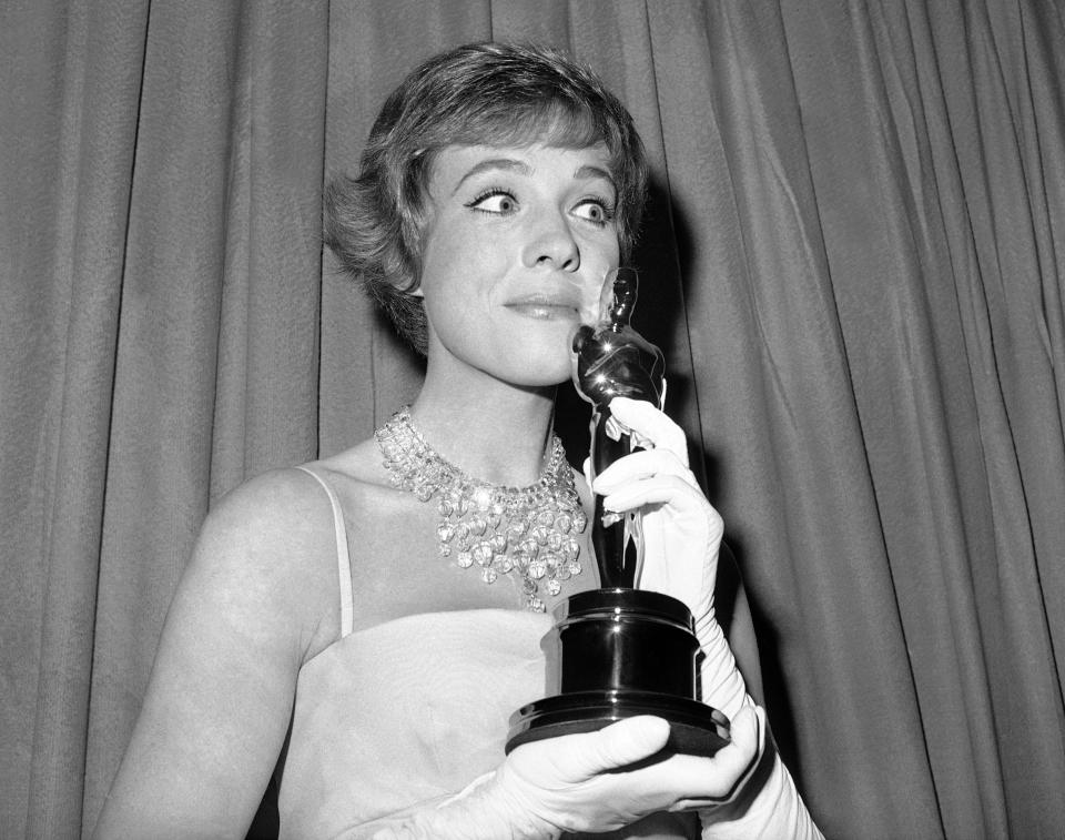 FILE - This April 6, 1965 file photo shows actress Julie Andrews holding her best actress Oscar for "Mary Poppins" in Santa Monica, Calif. Andrews released a memoir, “Home Work: A Memoir of My Hollywood Years,” which hits shelves on Oct. 15, 2019. (AP Photo, File)