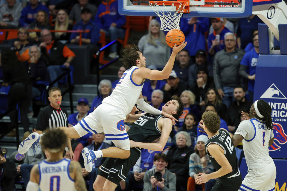 Boise State forward Tyson Degenhart (2) is fouled putting up a shot by Utah State center Isaac Johnson (20) in the second half of an NCAA college basketball game, Saturday, Jan. 27, 2024, in Boise, Idaho. Utah State won 90-84. (AP Photo/Steve Conner)