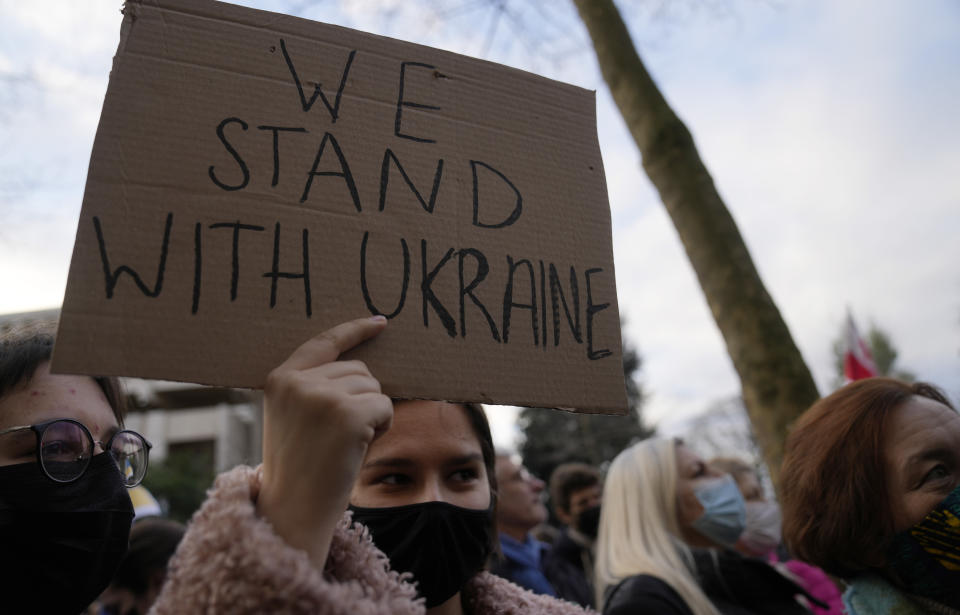 A protestor holds up a sign during a demonstration in front of the Russian embassy in Paris, France, Tuesday, Feb. 22, 2022. World leaders are getting over the shock of Russian President Vladimir Putin ordering his forces into separatist regions of Ukraine and they are focusing on producing as forceful a reaction as possible. Germany made the first big move Tuesday and took steps to halt the process of certifying the Nord Stream 2 gas pipeline from Russia. (AP Photo/Francois Mori)