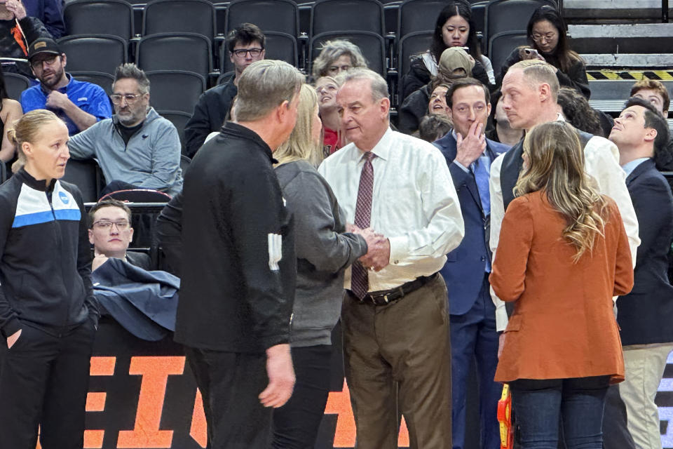 Texas head coach Vic Schaefer, center right, talks to officials before an Elite Eight college basketball game against North Carolina State in the women's NCAA Tournament, Sunday, March 31, 2024, in Portland, Ore. The 3-point line for the women's NCAA Tournament at Moda Center had a discrepancy in distance at each end of the court that went unnoticed through four games over two days before Texas and North Carolina State were informed of the problem ahead of their Elite Eight matchup on Sunday. (AP Photo/Anne Peterson)