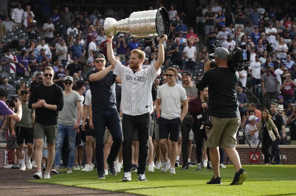 Colorado Avalanche captain Gabriel Landeskog holds up the Stanley Cup as the NHL hockey team was honored by the Colorado Rockies before the baseball team's game against the Los Angeles Dodgers on Wednesday, June 29, 2022, in Denver. (AP Photo/David Zalubowski)
