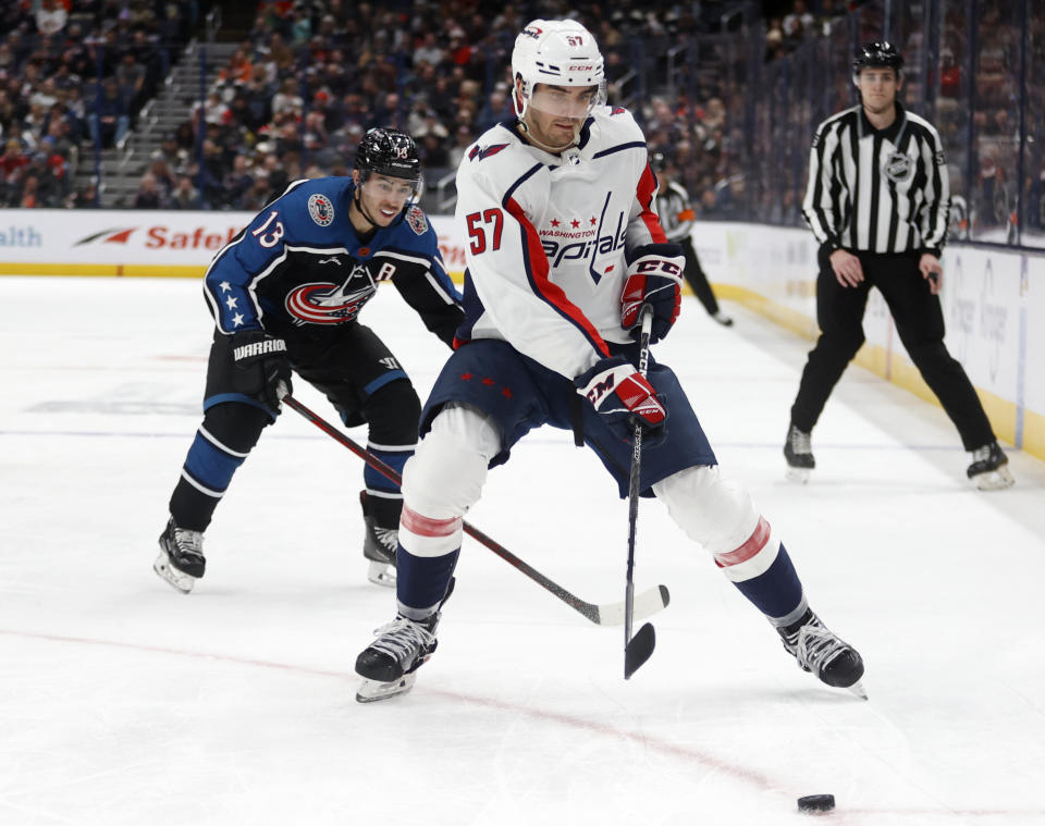 Washington Capitals defenseman Trevor van Riemsdyk, right, reaches for the puck in front of Columbus Blue Jackets forward Johnny Gaudreau during the second period of an NHL hockey game in Columbus, Ohio, Tuesday, Jan. 31, 2023. (AP Photo/Paul Vernon)