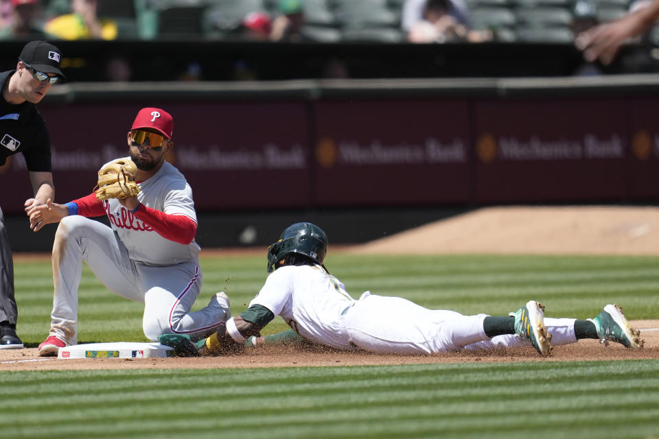 Oakland Athletics' Esteury Ruiz, right, steals third base against Philadelphia Phillies third baseman Edmundo Sosa during the fourth inning of a baseball game in Oakland, Calif., Saturday, June 17, 2023. (AP Photo/Jeff Chiu)