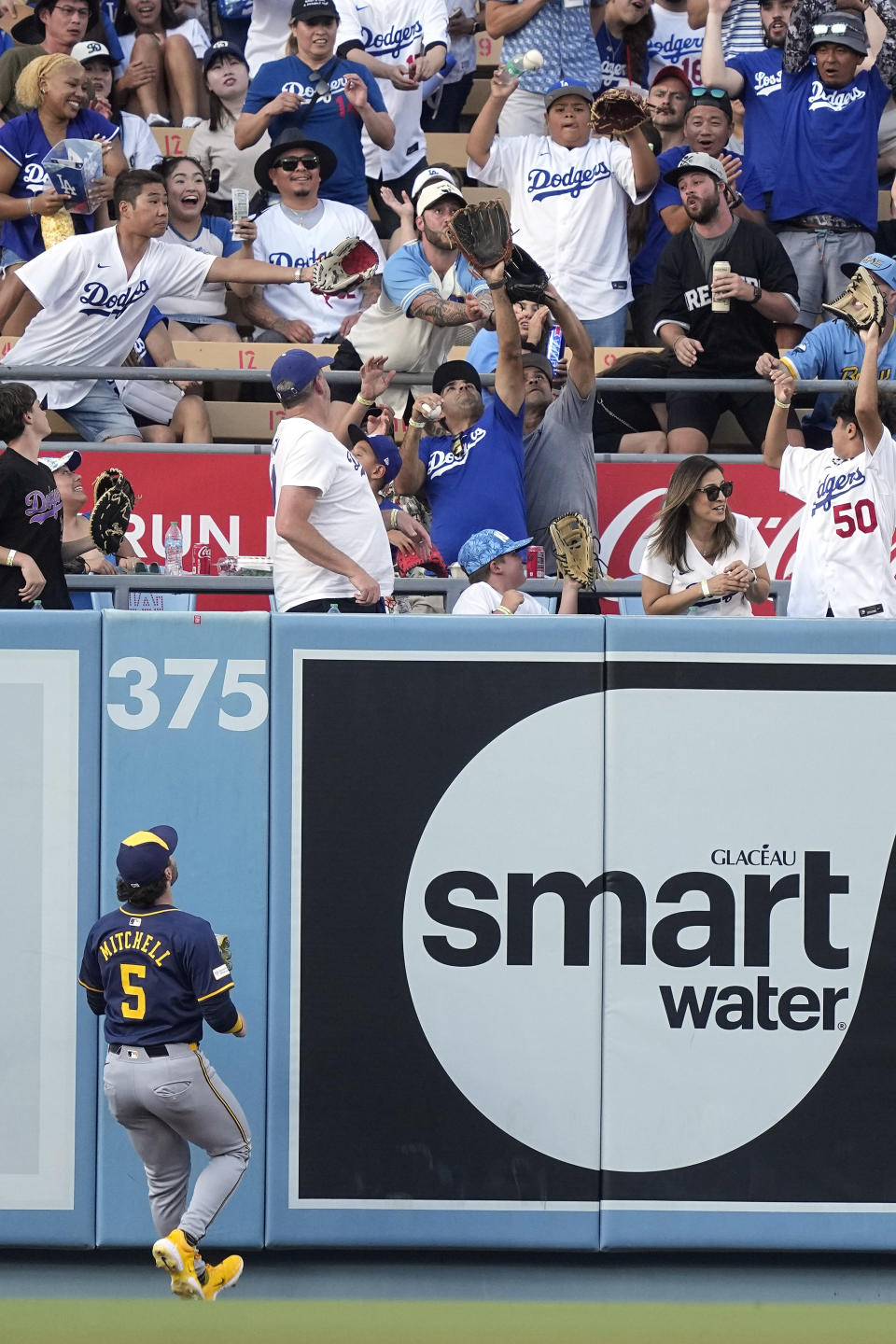 Milwaukee Brewers center fielder Garrett Mitchell watches a ball hit b y Los Angeles Dodgers' Will Smith go out for a solo home run during the first inning of a baseball game Friday, July 5, 2024, in Los Angeles. (AP Photo/Mark J. Terrill)