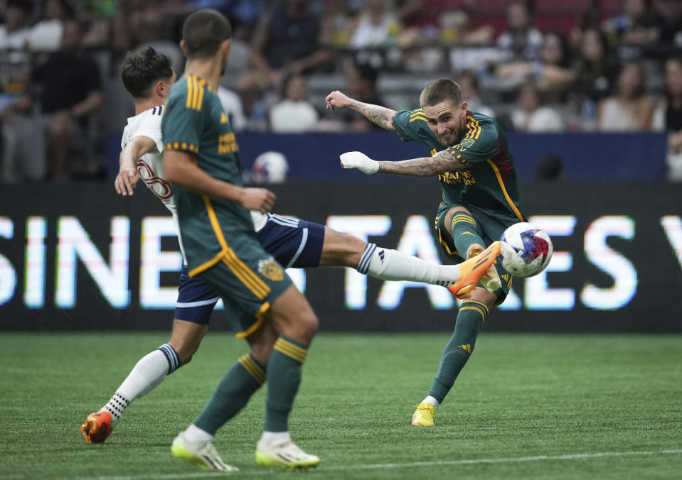 Los Angeles Galaxy's Tyler Boyd, right, shoots past Vancouver Whitecaps' Alessandro Schopf, back left, during the second half of an MLS soccer match Saturday, July 15, 2023, in Vancouver, British Columbia. (Darryl Dyck/The Canadian Press via AP)