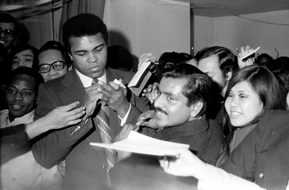 The future Muhammad Ali signs autographs for adoring fans two days before his Feb. 10, 1962, bout with Sonny Banks in New York. (Photo: Barratts/PA Images Archive via Getty Images)