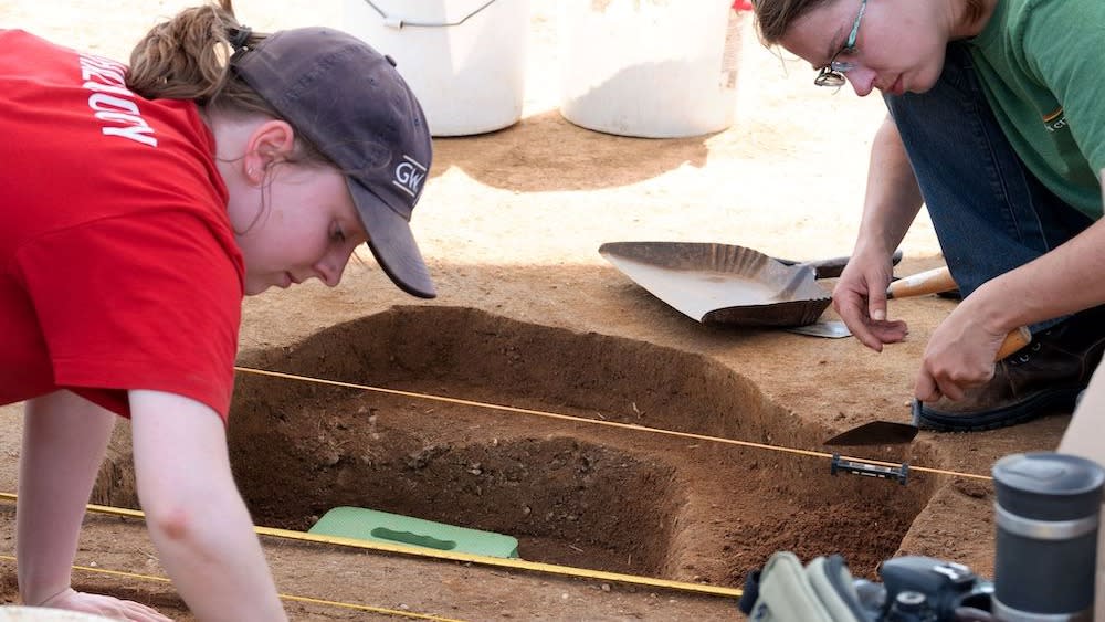  Two people dig at a burial site in Maryland.  