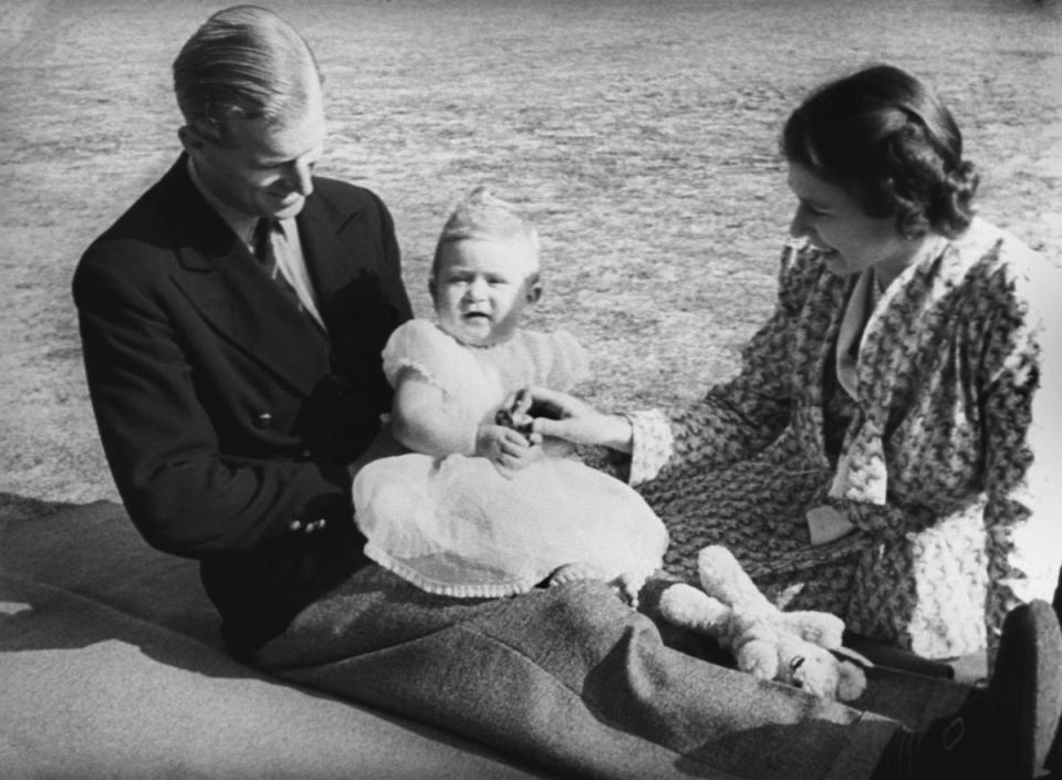 Prince Charles, later The Prince of Wales, perched on the lap of his father the Duke of Edinburgh, whilst his mother Queen Elizabeth II looks on in the grounds of Windlesham Moor, country home in Surrey of Princess Elizabeth and the Duke. (PA )