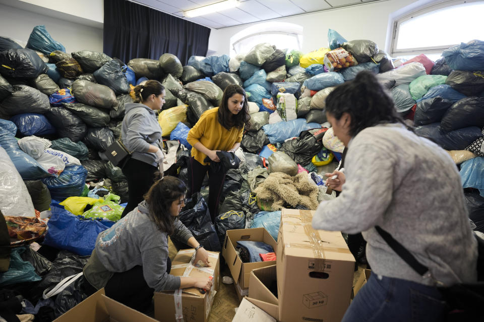 People sort and pack relief supplies in a packed room at a collection point of the Turkish community in Berlin, Germany, Tuesday, Feb. 7, 2023. Hundreds of members of Berlin's Turkish community flocked to a music school in the German capital to donate essential humanitarian supplies after the devastating earthquake that struck Turkey and Syria on Monday. (AP Photo/Markus Schreiber)