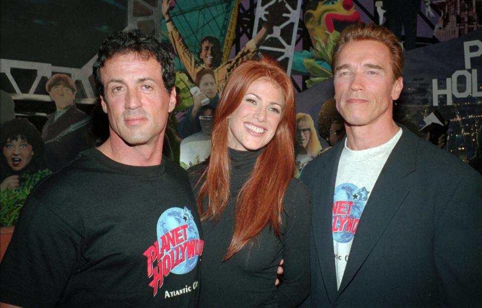 Sylvester Stallone, left, with then-fiancee Angie Everhart, center, and Arnold Schwarzenegger at the opening of Planet Hollywood in Atlantic City, N.J. in 1995.