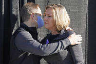 Jill and Matt McCluskey, the parents of slain University of Utah student-athlete Lauren McCluskey hug during a press conference announcing they have reached a settlement in their lawsuit against the University of Utah Thursday, Oct. 22, 2020, in Salt Lake City. (AP Photo/Rick Bowmer)