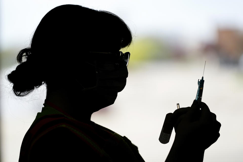 Sterling Heights firefighter Ashley Brouwer, who started her job in March 2021, prepares a syringe of Moderna vaccine at a distribution location in Sterling Heights, Mich., Wednesday, April 28, 2021. (AP Photo/Paul Sancya)