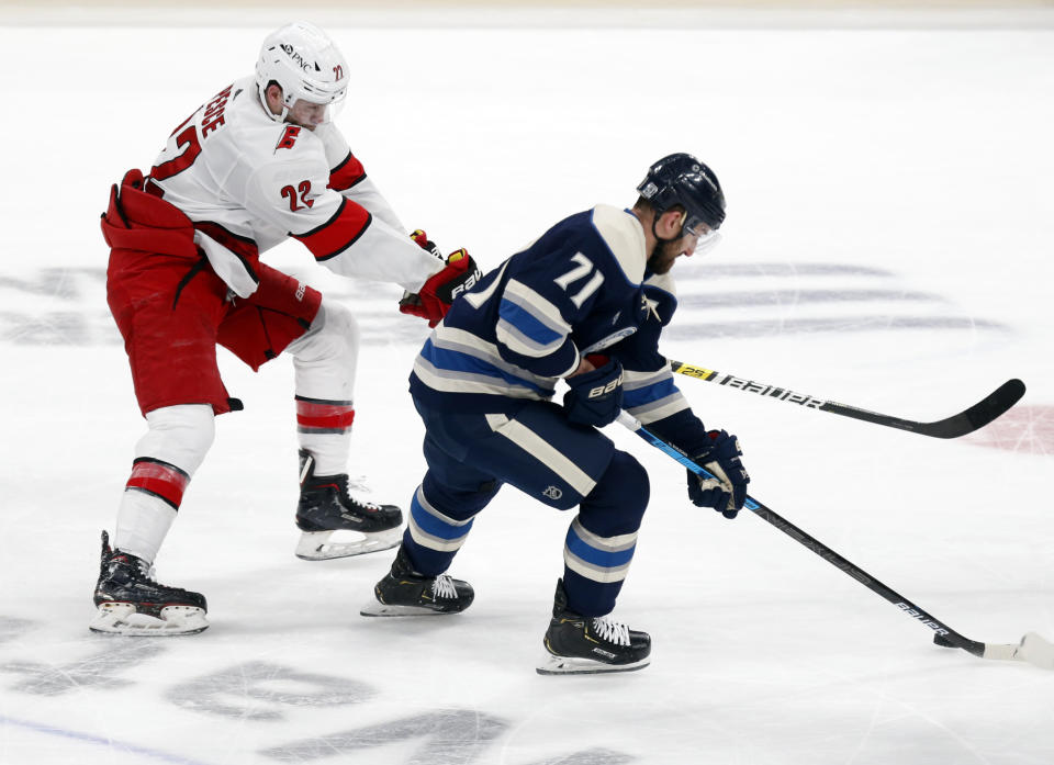 Columbus Blue Jackets forward Nick Foligno, right, controls the puck against Carolina Hurricanes defenseman Brett Pesce during the second period of an NHL hockey game in Columbus, Ohio, Sunday, Feb. 7, 2021. (AP Photo/Paul Vernon)