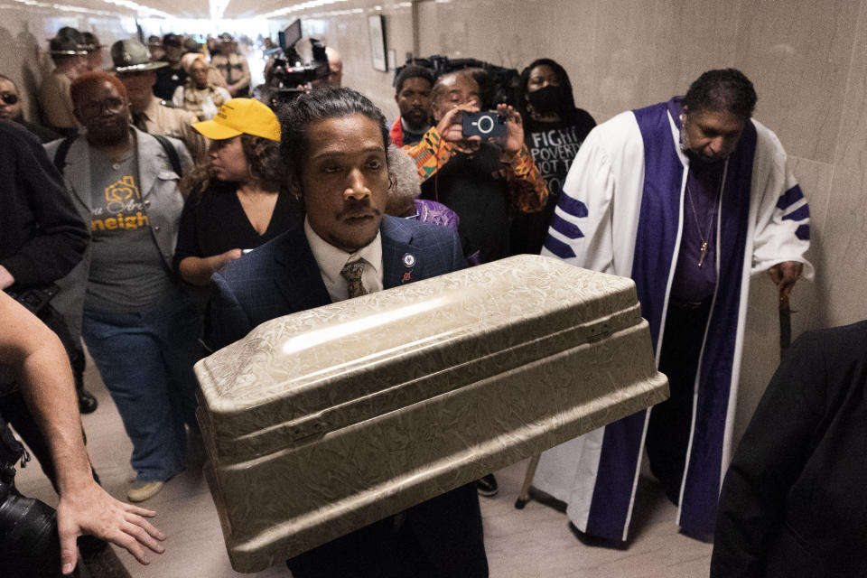 Rep. Justin Jones, D-Nashville, carries a casket through the halls of the state Capitol with Rev. William J. Barber, right, Monday, April 17, 2023, in Nashville, Tenn. (AP Photo/George Walker IV)