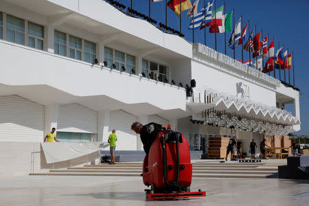 Workers clean the area in front of the entrance of the Palazzo del Cinema a day before the opening of the 74th Venice Film Festival in Venice, Italy August 29, 2017. REUTERS/Alessandro Bianchi