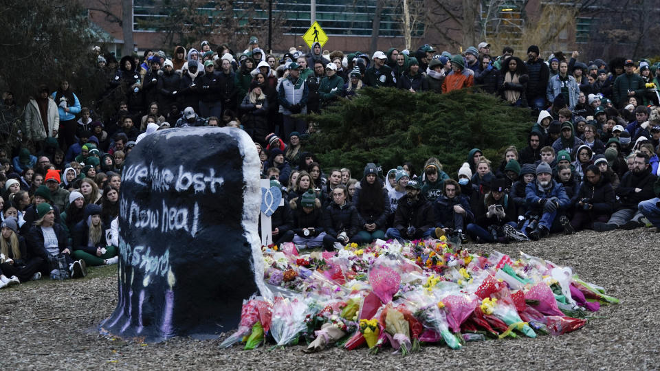 Mourners sit at The Rock on the grounds of Michigan State University in East Lansing, Mich., Wednesday, Feb. 15, 2023. Alexandria Verner, Brian Fraser and Arielle Anderson were killed and several other students remain in critical condition after a gunman opened fire on the campus of Michigan State University Monday night. (AP Photo/Paul Sancya)