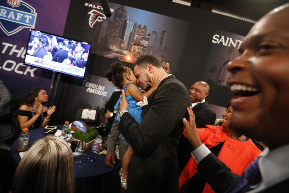 Mike Evans, from Texas A&M, holds his 2-year-old daughter Mackenzie as he reacts after being selected seventh overall by the Tampa Bay Buccaneers in the first round of the NFL football draft, Thursday, May 8, 2014, at Radio City Music Hall in New York. (AP Photo/Jason DeCrow)