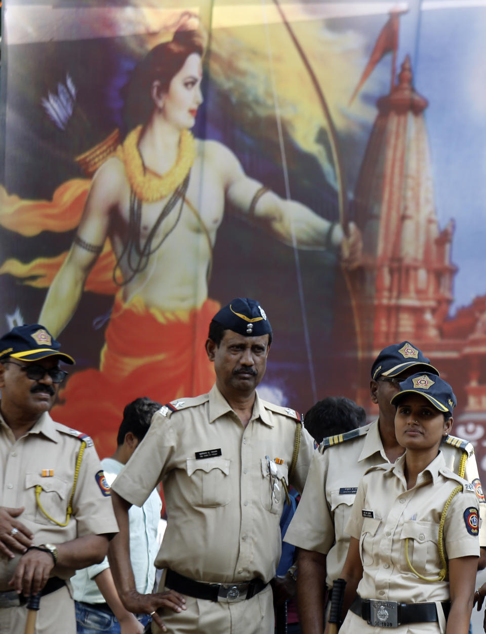 Police officers stand guard in front of a poster of Hindu god Rama outside the Bhartiya Janata Party (BJP) head office in Mumbai, Saturday, Nov. 9, 2019. India's Supreme Court on Saturday ruled in favor of a Hindu temple on a disputed religious ground and ordered that alternative land be given to Muslims to build a mosque. The dispute over land ownership has been one of the country's most contentious issues. (AP Photo/Rajanish Kakade)