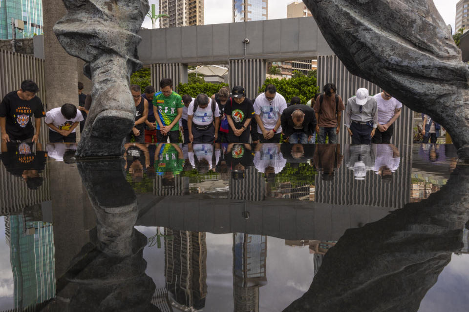 Fans gather in front of the statue of martial artist Bruce Lee to commemorate the 50th anniversary of his death in Hong Kong, Thursday, July 20, 2023. (AP Photo/Louise Delmotte)